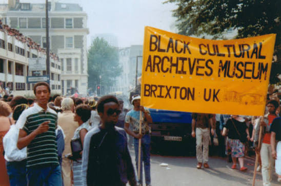 A Black Cultural Archives Museum banner carried through a Brixton street procession