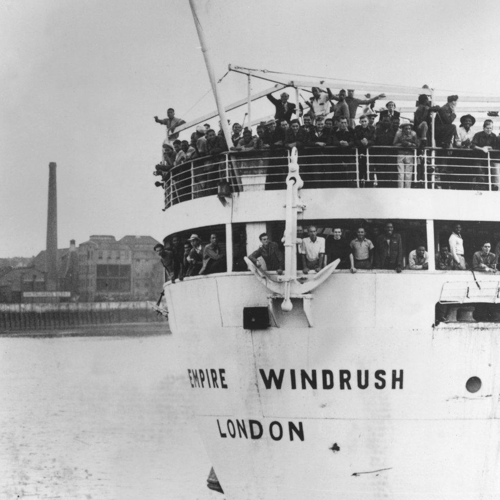 Passengers waving from the deck of the Empire Windrush on arrival in London